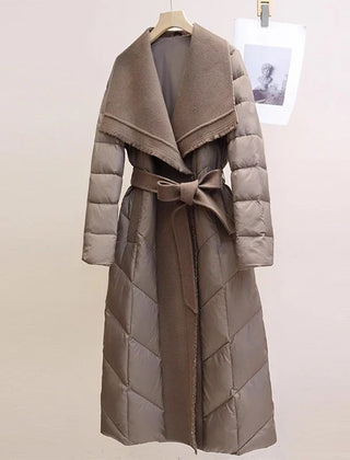 Long belted puffer jacket for women by Christine Brewer, featuring a cozy quilted design and a stylish belt detail.