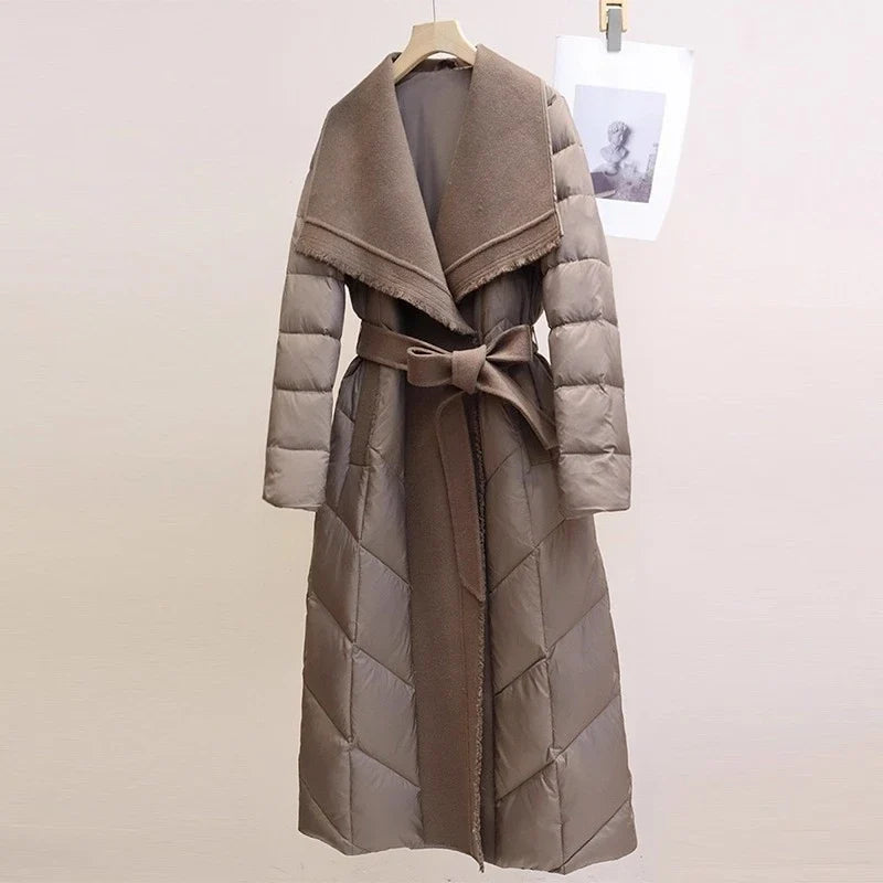 Long belted puffer jacket for women by Christine Brewer, featuring a cozy quilted design and a stylish belt detail.