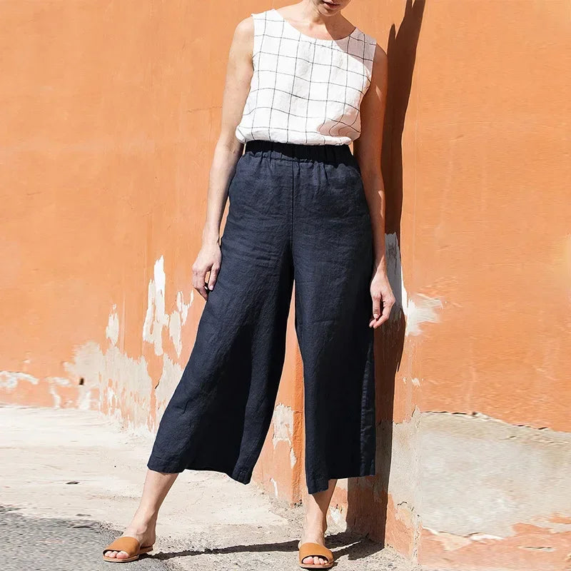 Light beige linen cropped wide-leg women's trousers with drawstring waist and loose fit, styled for casual comfort.