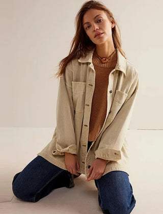 Christine Brewer Charlotte oversized women's denim shirt jacket displayed on a hanger, showcasing classic blue denim with button closure.