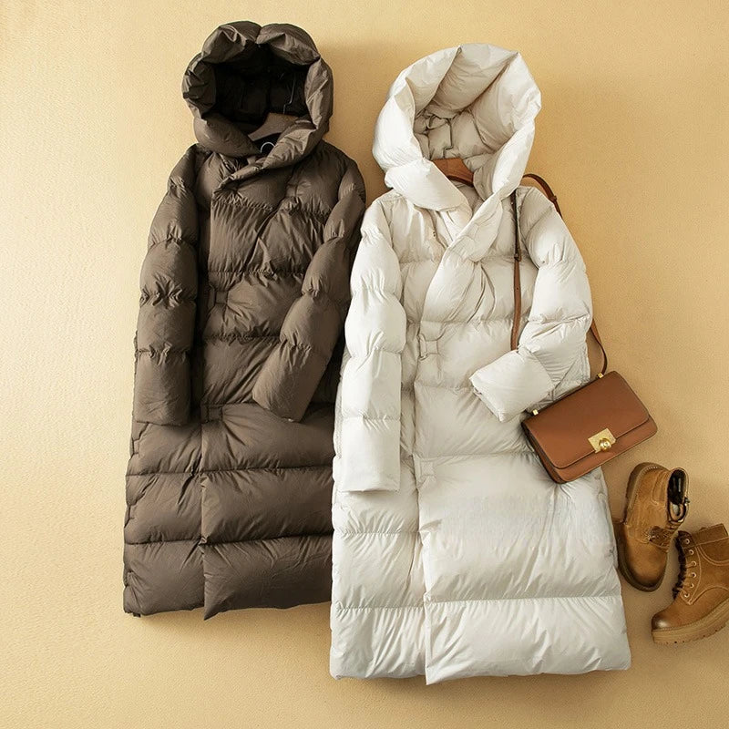 Long hooded women's parka by Christine Brewer, featuring a stylish design and functional hood for cold weather protection.