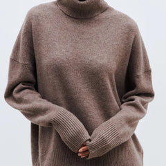 Cream-colored Erica oversized turtleneck sweater for women by Christine Brewer, featuring a cozy, relaxed fit and ribbed cuffs.