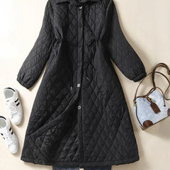 Longline black puffer jacket for women by Christine Brewer, featuring a warm, quilted design and a hooded style.