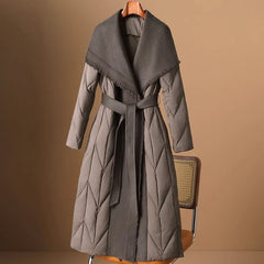 Women’s long belted puffer jacket by Christine Brewer, featuring a stylish, insulated design with a belt for a fitted look.