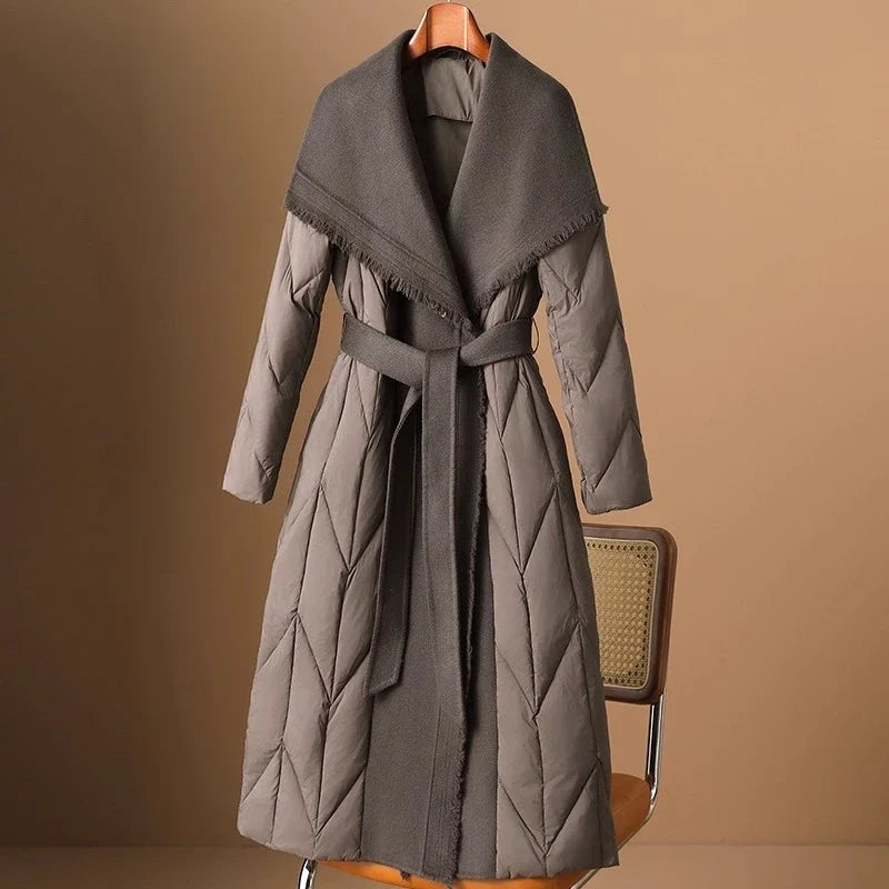 Women’s long belted puffer jacket by Christine Brewer, featuring a stylish, insulated design with a belt for a fitted look.