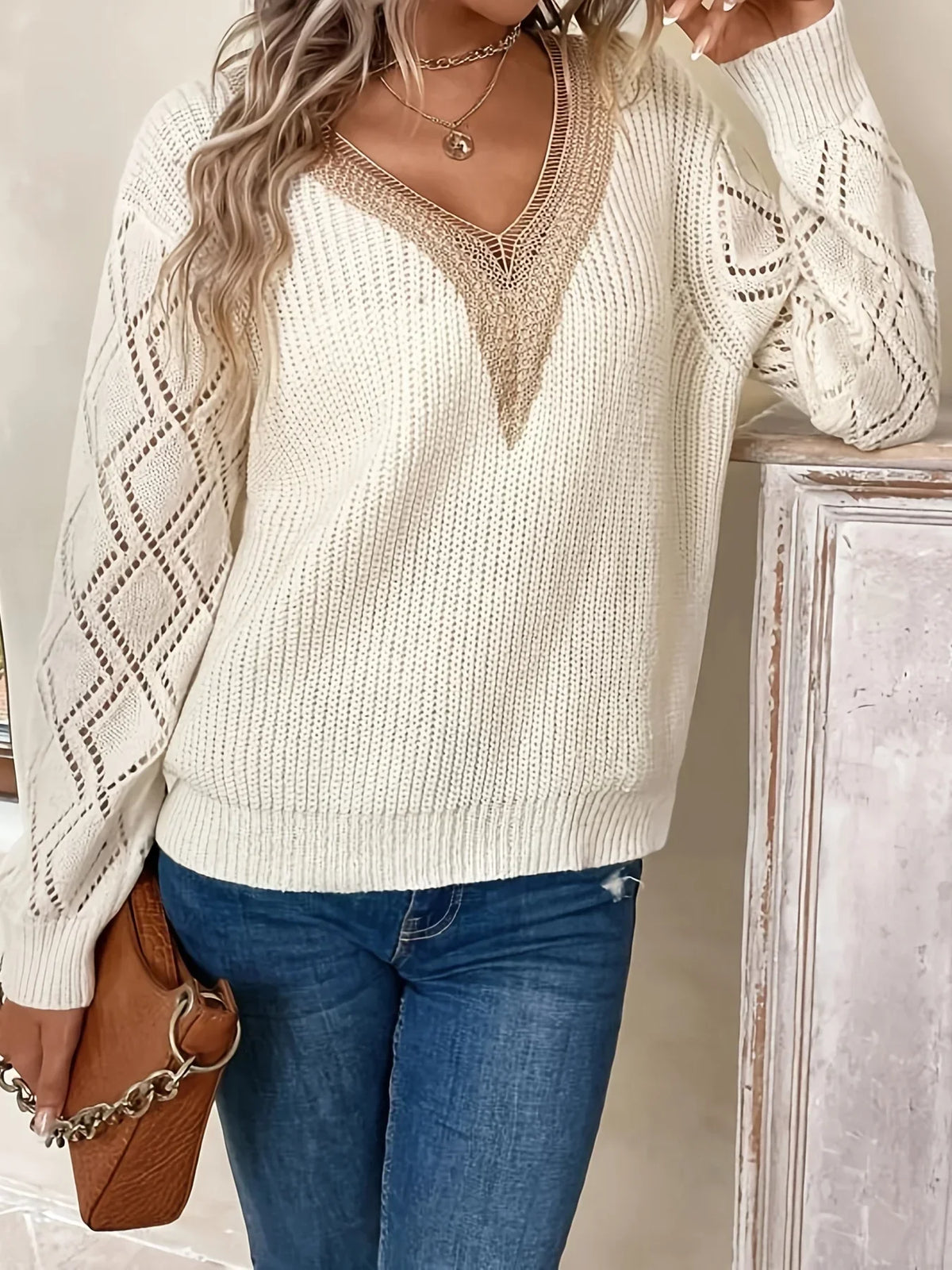 Beige V-neck sweater for women by Christine Brewer, featuring a relaxed fit and soft knit fabric, styled on a model.