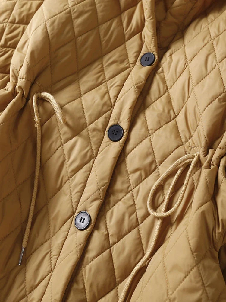 Longline puffer jacket for women by Christine Brewer, featuring a warm, quilted design and hooded style for winter wear.