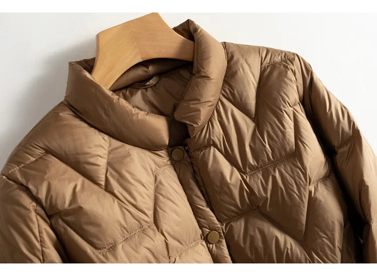 Women’s Aurora short quilted puffer jacket by Christine Brewer, featuring a stylish, insulated design with a high collar and quilted pattern.