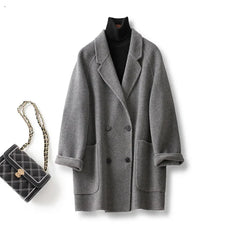 Brown double-breasted wool coat for women by Christine Brewer, shown on a model with classic lapels and tailored fit.