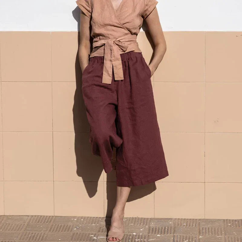 Light beige linen cropped wide-leg trousers for women with drawstring waist and loose fit, designed by Christine Brewer.