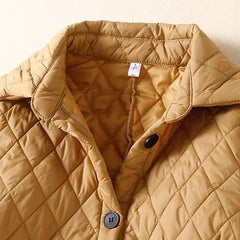 Longline puffer jacket for women by Christine Brewer, featuring a stylish, insulated design with a high collar and quilted exterior.