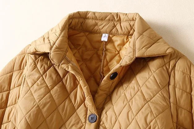 Longline puffer jacket for women by Christine Brewer, featuring a stylish, insulated design with a high collar and quilted exterior.