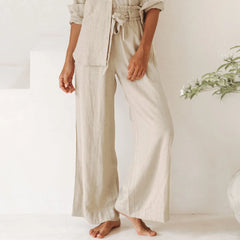 Light beige linen wide-leg trousers for women with a loose pull-on design, styled casually on a model.