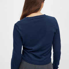 Woman wearing a beige knit cardigan with buttons, styled with a casual outfit, from the Christine Brewer Finley women's knit cardigan collection.
