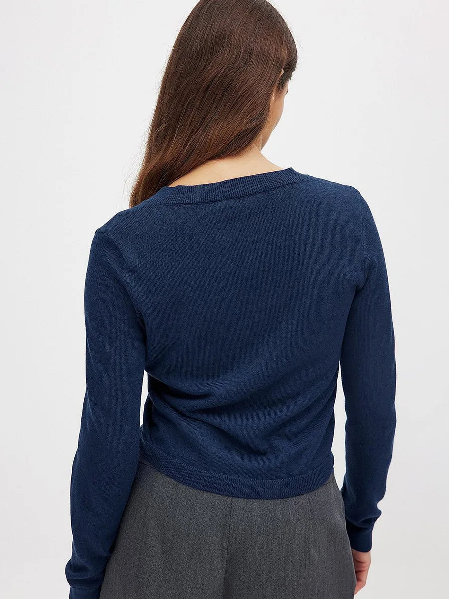 Woman wearing a beige knit cardigan with buttons, styled with a casual outfit, from the Christine Brewer Finley women's knit cardigan collection.
