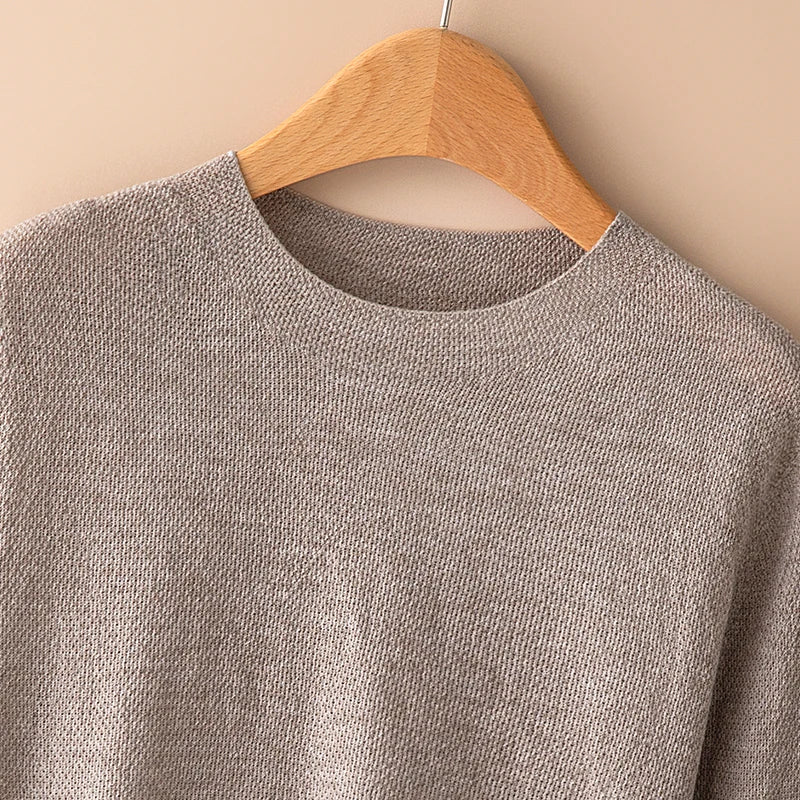 Woman wearing a gray wool sweater by Christine Brewer, featuring a cozy fit and classic design perfect for casual wear.
