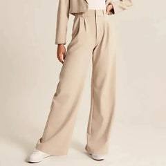 White wide-leg high-waist pants for women by Christine Brewer, shown on a model, featuring a relaxed fit and elegant style.