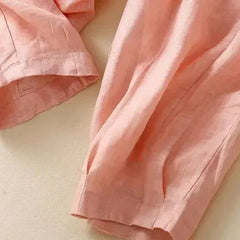 Light beige tapered linen trousers for women by Christine Brewer, featuring a loose pull-on style and relaxed fit.