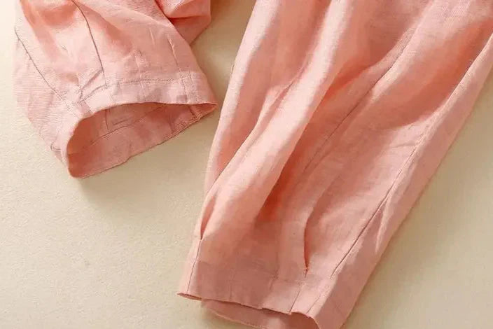 Light beige tapered linen trousers for women by Christine Brewer, featuring a loose pull-on style and relaxed fit.