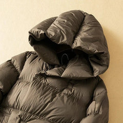 Long hooded women's parka by Christine Brewer featuring a cozy design and practical hood for cold weather comfort.