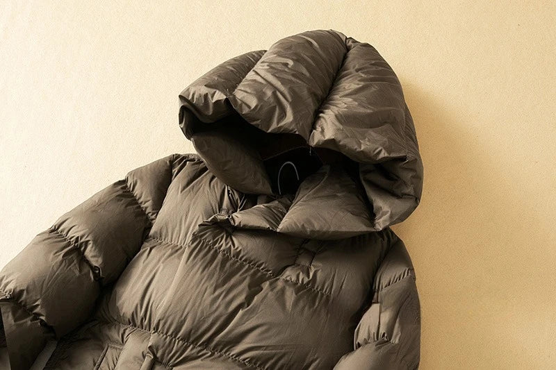 Long hooded women's parka by Christine Brewer featuring a cozy design and practical hood for cold weather comfort.