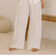 Light beige linen wide-leg trousers for women, loose pull-on style from Christine Brewer, shown laid flat on a white background.