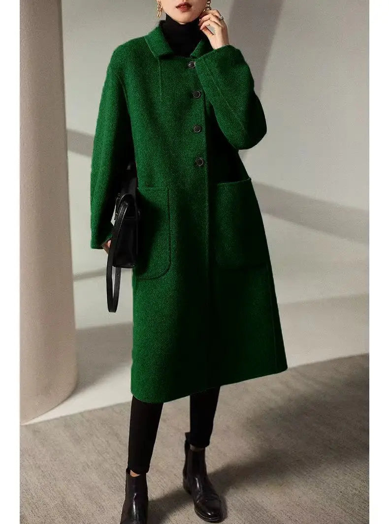 Green wool long coat for women by Christine Brewer, shown on a model, featuring a classic tailored design and soft fabric.