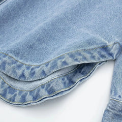Woman wearing a relaxed denim shirt jacket by Christine Brewer, featuring classic denim fabric and a casual fit.