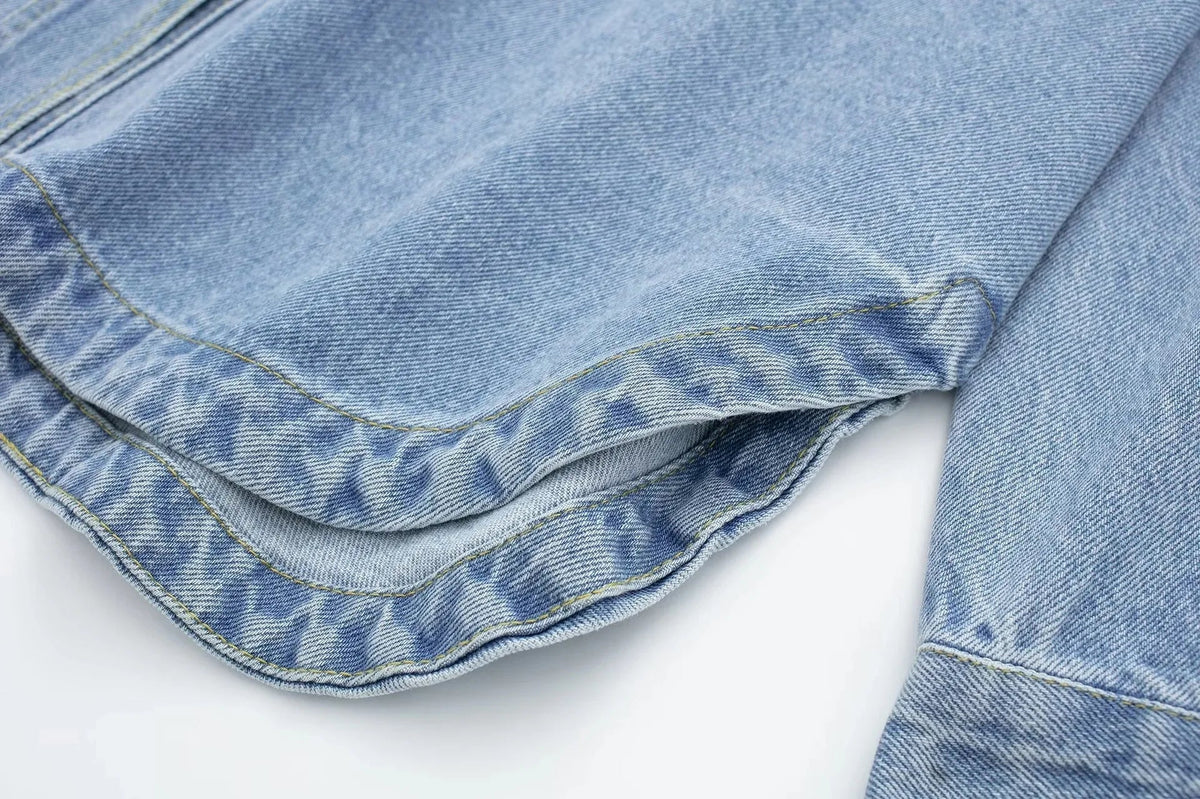 Woman wearing a relaxed denim shirt jacket by Christine Brewer, featuring classic denim fabric and a casual fit.