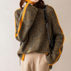 Woman wearing a beige knit sweater by Christine Brewer Vera collection, featuring a cozy, textured design and round neckline.