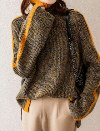 Woman wearing a beige knit sweater by Christine Brewer Vera collection, featuring a cozy, textured design and round neckline.