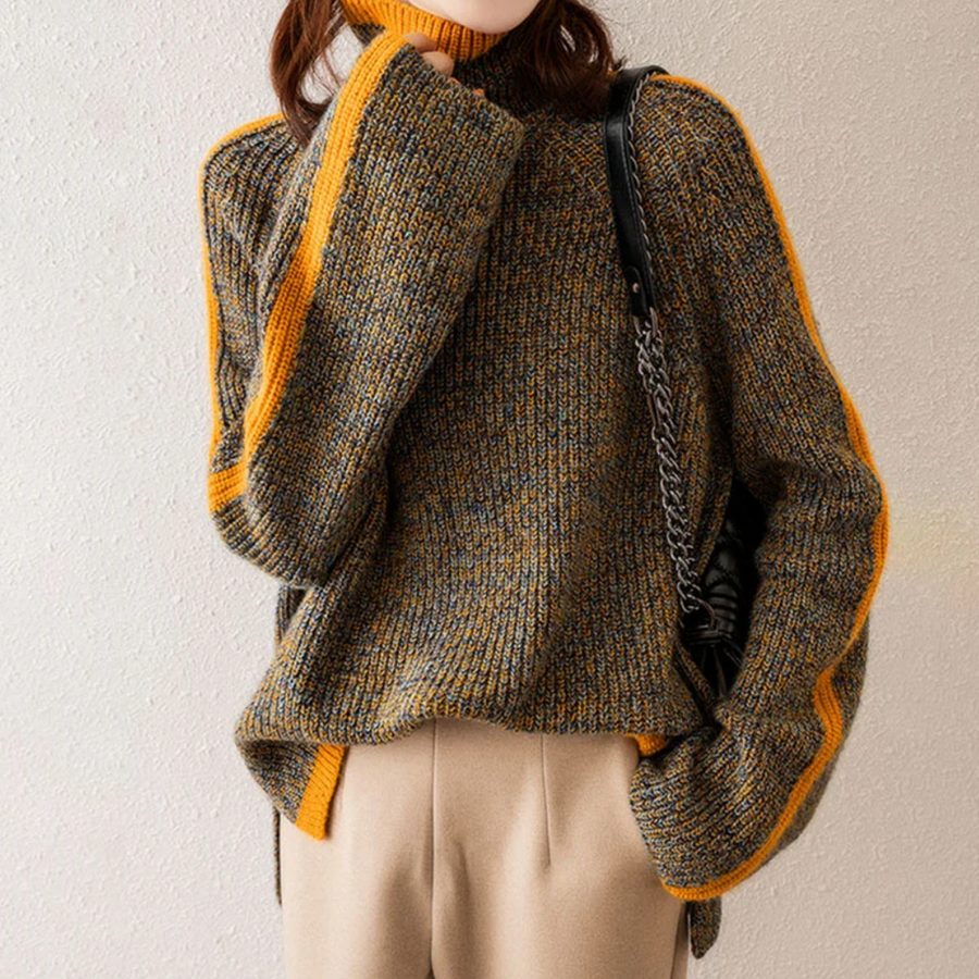 Woman wearing a beige knit sweater by Christine Brewer Vera collection, featuring a cozy, textured design and round neckline.