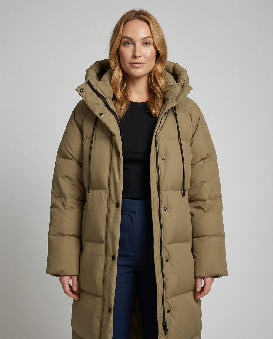 Long puffer jacket for women by Christine Brewer, featuring a stylish design and warm padding, shown on a model.