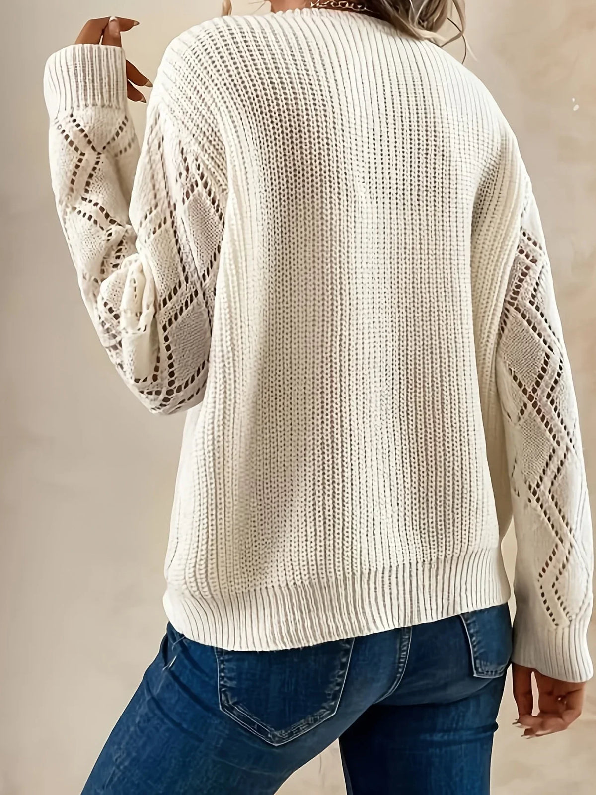 Beige V-neck sweater for women by Christine Brewer, featuring a relaxed fit and soft knit fabric, showcased on a model.