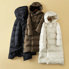 Long hooded parka for women by Christine Brewer, featuring a stylish design and cozy hood, perfect for cold weather.