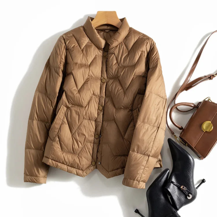 Women’s Aurora short quilted puffer jacket by Christine Brewer, lightweight with a shiny quilted exterior, ideal for cold weather.