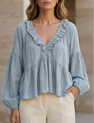 Sky blue women's summer blouse with v-neck, long sleeves, and ruffle details from Christine Brewer, made of denim fabric.