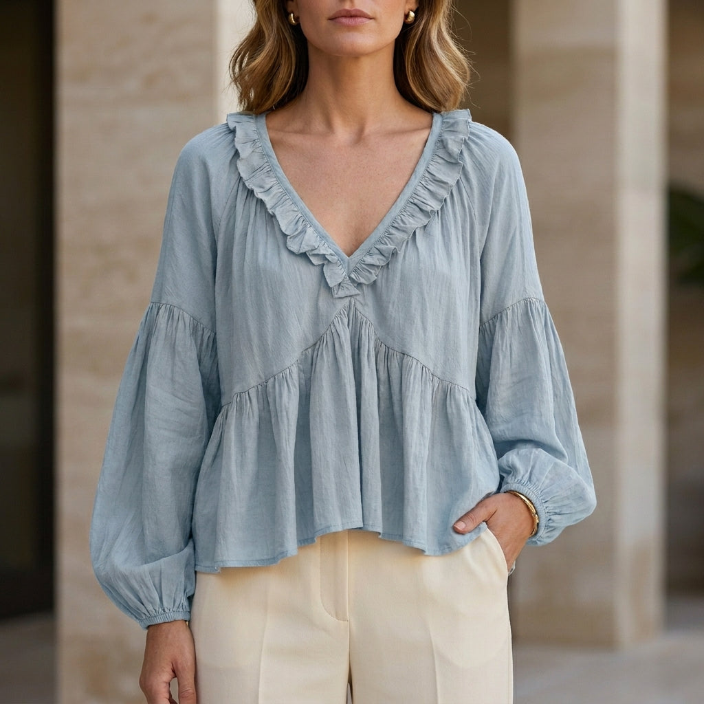 Sky blue women's summer blouse with v-neck, long sleeves, and ruffle details from Christine Brewer, made of denim fabric.