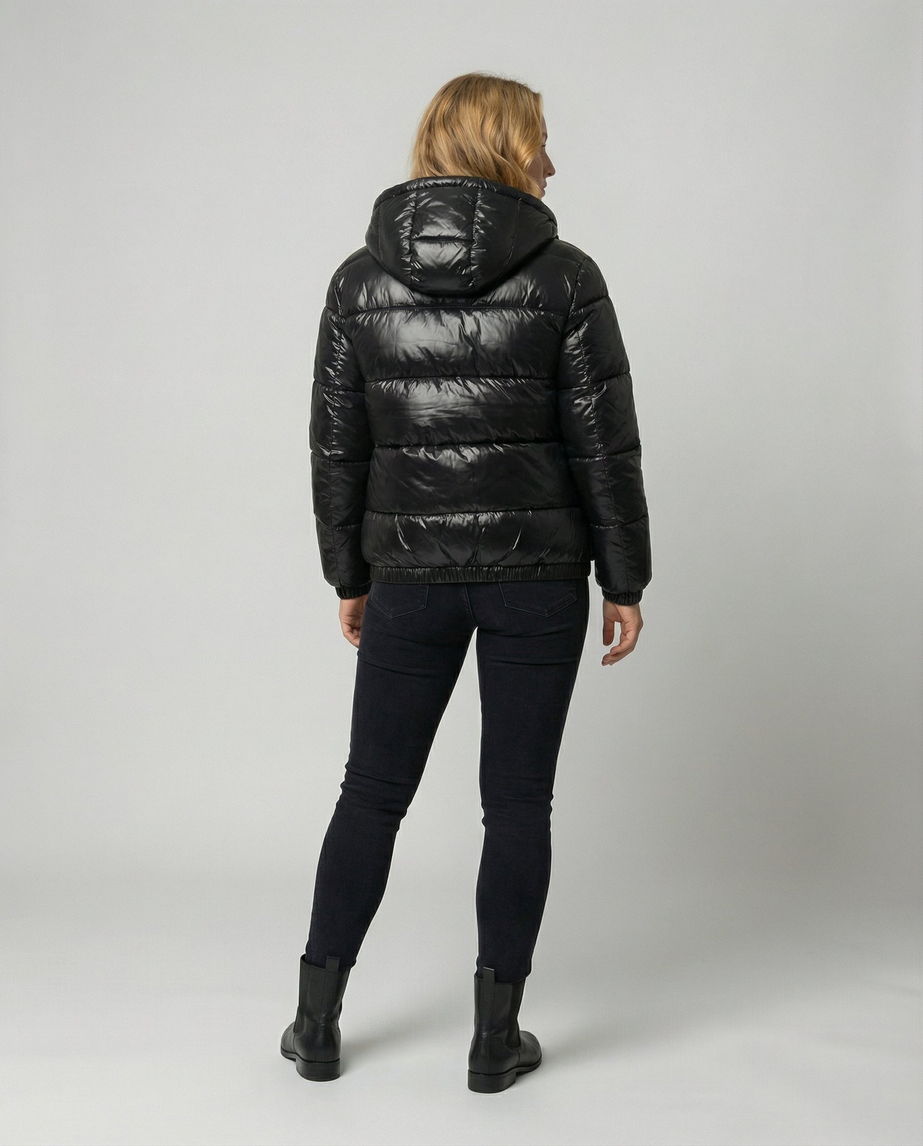 Unisex black Eva puffer jacket by Christine Brewer, shown from the back, featuring a cozy, quilted design for women and men.