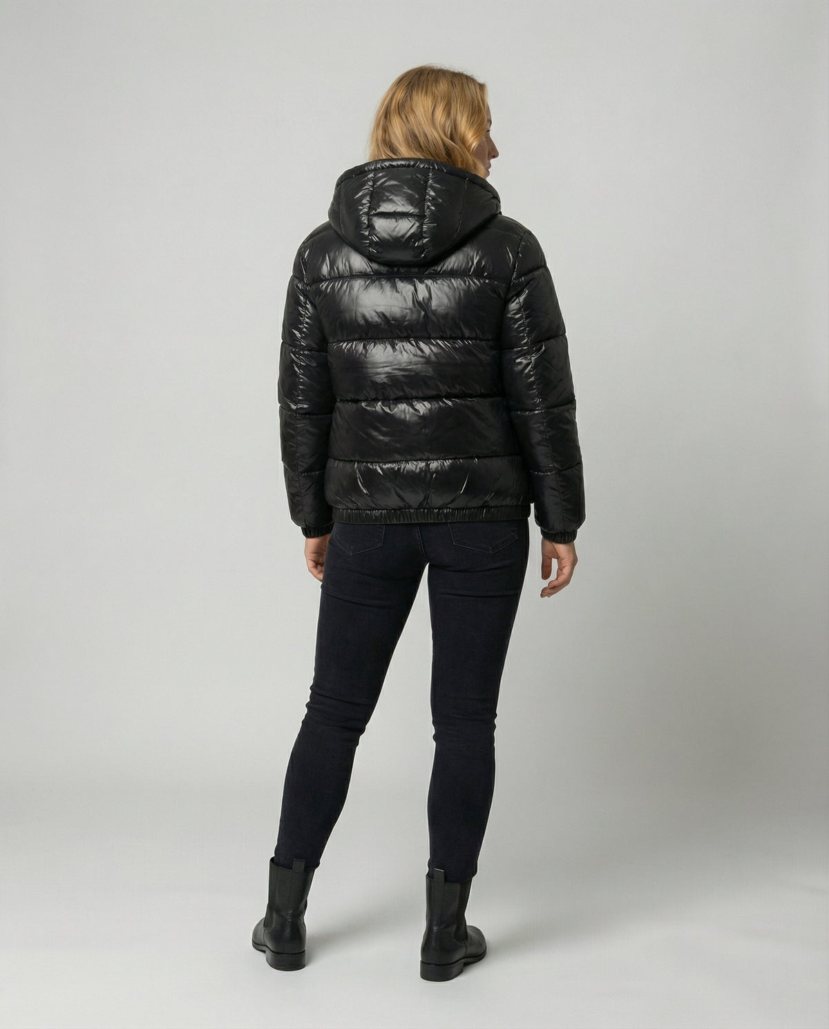 Unisex black Eva puffer jacket by Christine Brewer, shown from the back, featuring a cozy, quilted design for women and men.
