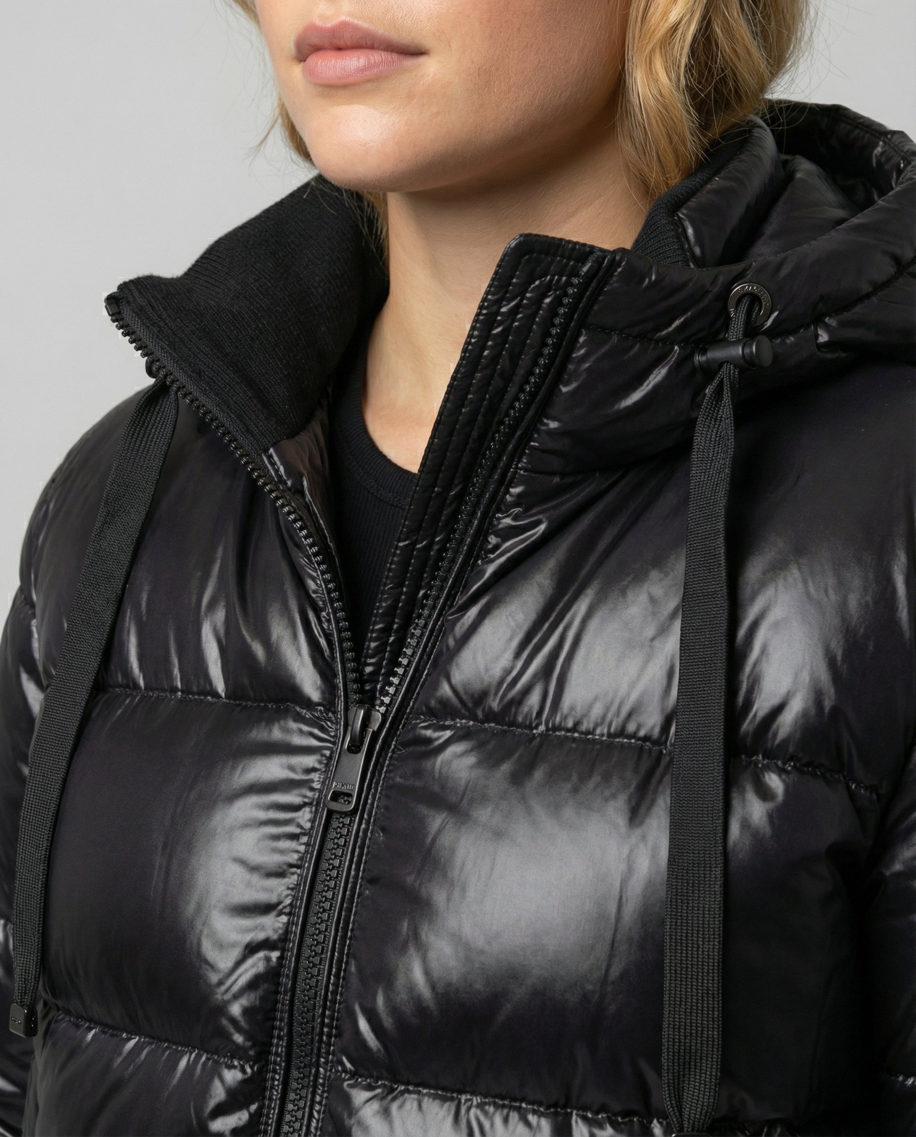 Close-up of Christine Brewer Eva Cosy Puffer Jacket for women, featuring black, quilted design and detailed stitching.