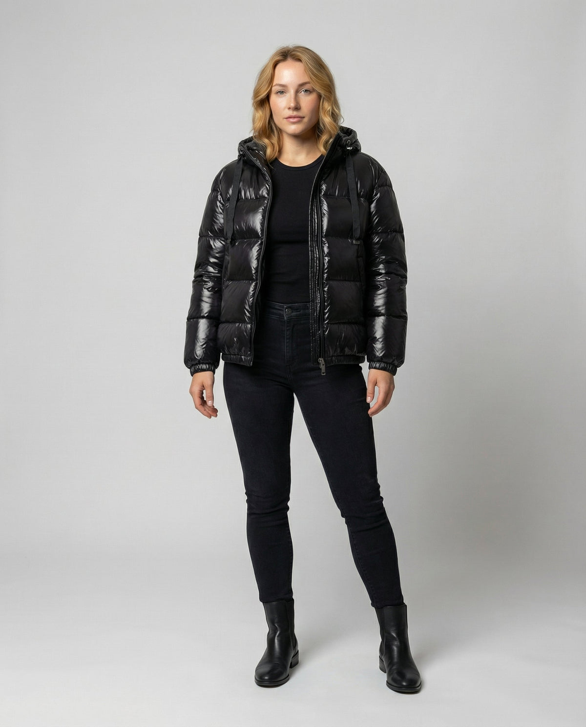Unisex black puffer jacket from Christine Brewer's Eva collection, full body front view showcasing its cozy, quilted design.