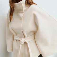 Women’s spring belted high-neck cape coat with funnel collar and cape sleeves, stylishly designed by Christine Brewer.