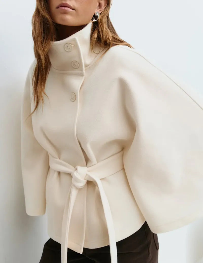 Women’s spring belted high-neck cape coat with funnel collar and cape sleeves, stylishly designed by Christine Brewer.