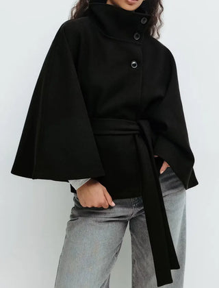 Women’s spring belted high-neck cape coat by Christine Brewer, featuring a funnel neck, short sleeves, and waist belt detail.