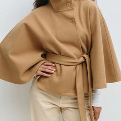 Women’s spring belted high-neck cape coat by Christine Brewer featuring a funnel neck, waist belt, and cape sleeves.