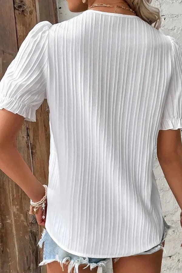 White V-neck blouse for women with puff sleeves by Christine Brewer, shown on a model. Stylish and elegant women's blouse.