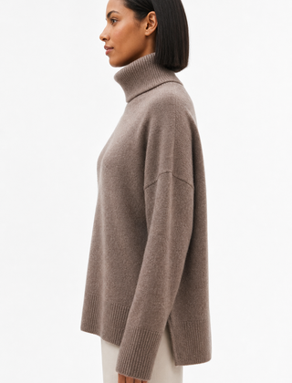 Cream-colored Erica oversized turtleneck sweater for women by Christine Brewer, featuring a cozy, relaxed fit and ribbed details.