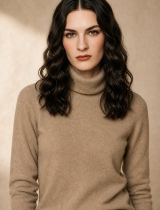 Cream-colored Gabrielle cashmere turtleneck sweater for women, styled with a relaxed fit and ribbed cuffs, by Christine Brewer.