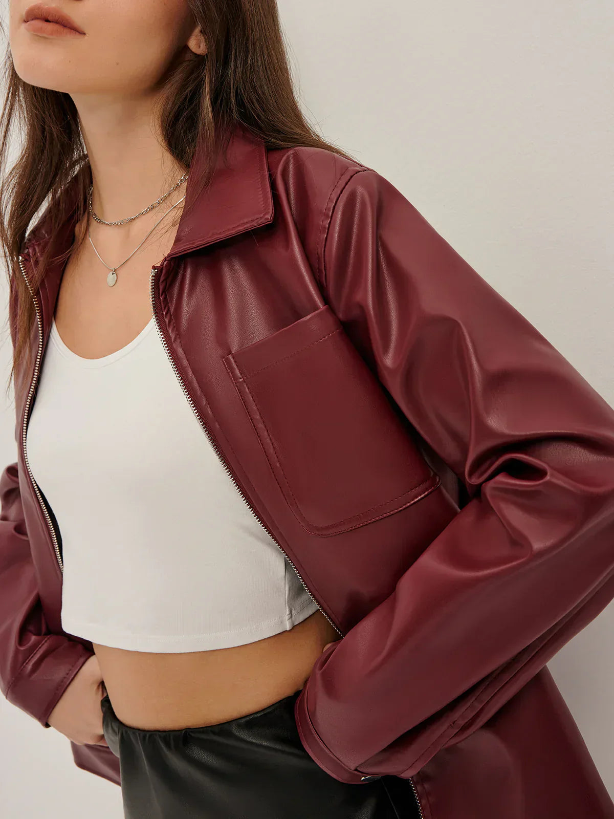Black zip-up faux leather jacket for women by Christine Brewer, featuring a sleek design and collar detail.